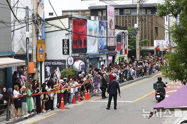 [서울=뉴시스] 김근수 기자 = 방탄소년단(BTS) 멤버 RM, 뷔의 전역날인 10일 오전 서울 용산구 하이브 사옥 앞에서 방탄소년단(BTS) 팬들이 멤버들의 제대를 축하하며 노래를 부르고 있다. 2025.06.10. ks@newsis.com