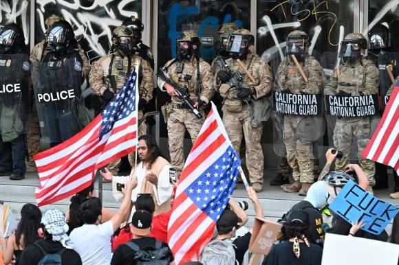 2025년 6월 10일(현지시간) 미국 캘리포니아주 로스앤젤레스(LA) 연방 청사 앞에서 정부의 불법 이민자 단속에 반대하는 시위가 계속되는 가운데 주방위군 병사들과 연방 경찰관들이 경비를 서고 있다. AFP 연합뉴스