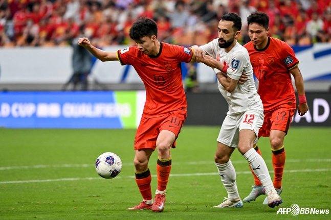 왕위동(왼쪽)이 10일(한국시간) 중국 충칭의 롱싱 축구 경기장에서 열린 2026 국제축구연맹(FIFA) 북중미월드컵 3차 예선 최종전에서 바레인 수비를 상대로 드리블을 시도하고 있다. /AFPBBNews=뉴스1