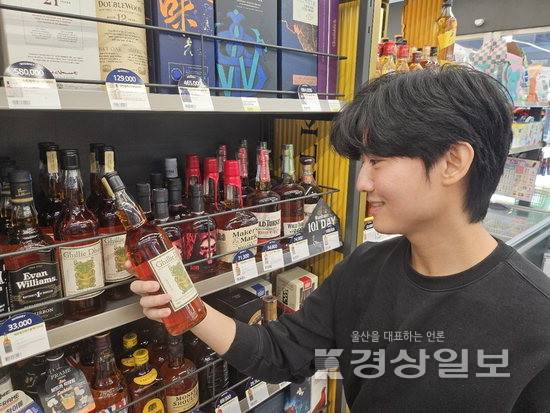 ▲ 고물가 시대에 초저가 위스키가 인기를 끌고 있다. 사진은 CU편의점이 판매하고 있는 위스키 '길리듀'를 들고 있는 모델. 길리듀는 초저가 위스키 마케팅으로 판매량이 급증하고 있다. BGF리테일 제공