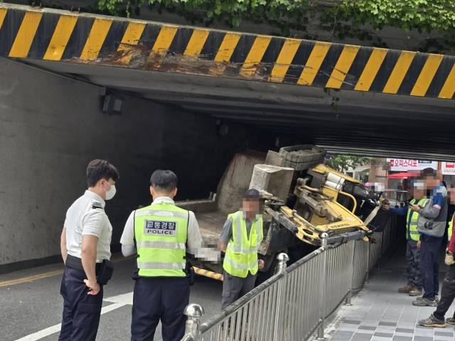 12일 낮 12시께 부산 부산진구 부전동 부전제1가도교 아래로 1t 트럭에 실려 지나던 미니 굴삭기가 구조물에 걸리면서 옆으로 쓰러졌다. 부산 부산진경찰서 제공