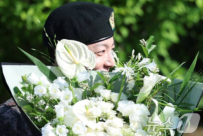 방탄소년단(BTS)의 정국이 11일 오전 경기도 연천군 연천공설운동장에서 군 복무를 마친 뒤 꽃다발을 받고 수줍은 미소를 짓고 있다. 정국과 지민은 지난 2023년 12월 입대해 경기도 연천에 위치한 육군 제5보병사단에서 약 1년 7개월간 병역의 의무를 성실히 수행했다. 2025.6.11/뉴스1 ⓒ News1 권현진 기자