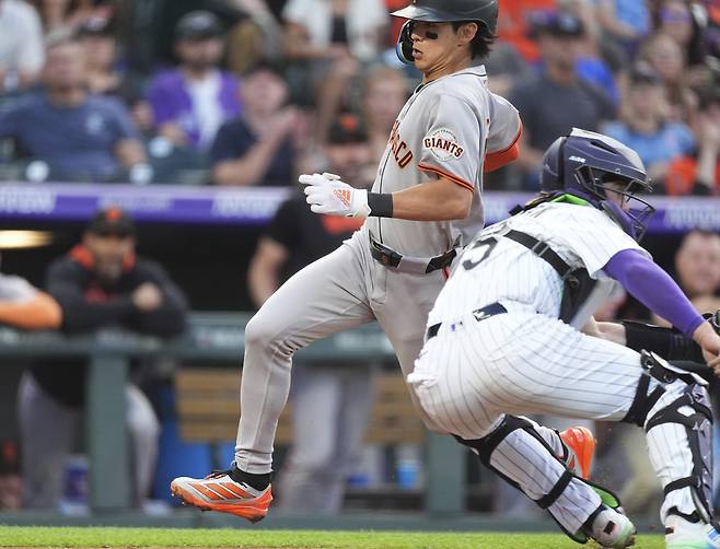 샌프란시스코 자이언츠 이정후가 12일(한국시각) 쿠어스필드에서 벌어진 콜로라도 로키스전에서 3회초 3루타를 치고 나간 뒤 윌리 아다메스의 우익수 희생플라이 때 태그업해 포수 헌터 굿맨을 피해 홈을 밟고 있다. AP연합뉴스