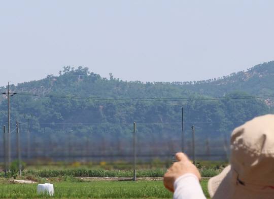 북한이 우리 군의 대북 확성기 방송 중지에 호응해 대남 소음 방송을 멈춘 것으로 보이는 12일 인천 강화군 송해면 당산리 주민들이 북한 개풍군 야산에 설치된 북한 대남 방송 스피커를 가리키고 있다.<연합뉴스 사진>