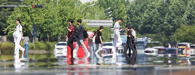 초여름 더위가 이어진 지난 11일 대구 달서구 호산동 달구벌대로에서 시민들이 햇볕에 달구어진 도로를 건너고 있다. 연합뉴스