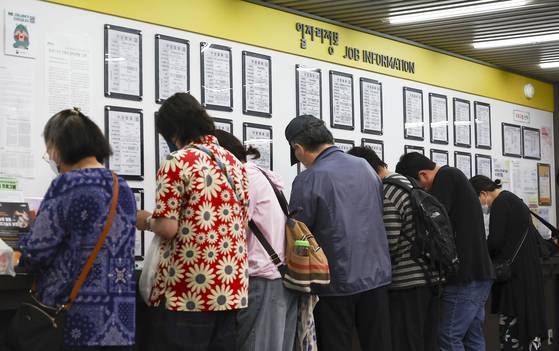 11일 서울 서부고용복지플러스센터 게시판 앞에서 구직자들이 이력서를 쓰고 있다. [뉴시스]