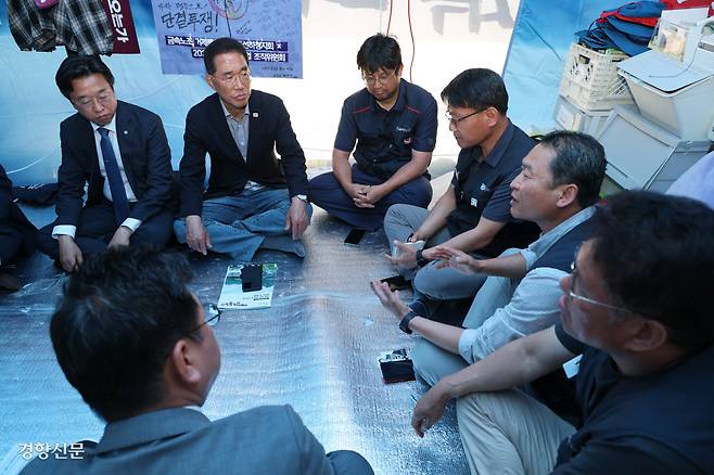 국회 환경노동위원회 소속 더불어민주당 의원들이 12일 서울 중구 한화빌딩 앞 김형수 금속노조 거제통영고성조선하청지회장의 고공농성장을 찾아 노조원들과 대화를 하고 있다.  성동훈 기자 zenism@kyunghyang.com