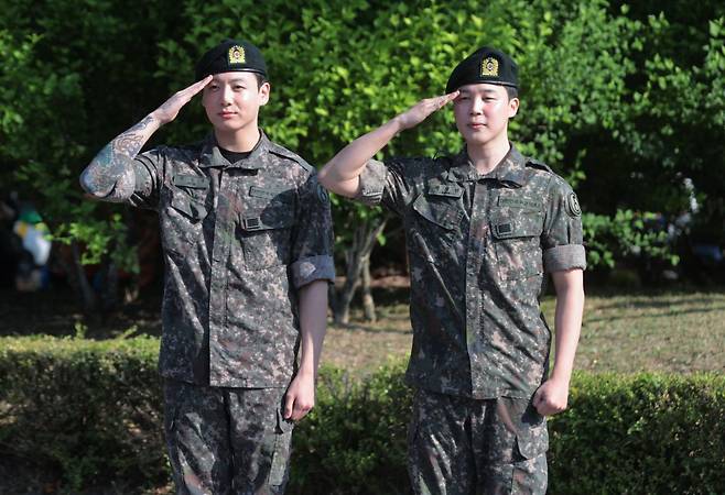 육군 현역 복무를 마치고 만기 전역한 그룹 방탄소년단(BTS) 지민과 정국이 11일 경기도 연천군 연천공설운동장에서 취재진과 팬들을 향해 거수 경례하고 있다. 연합뉴스