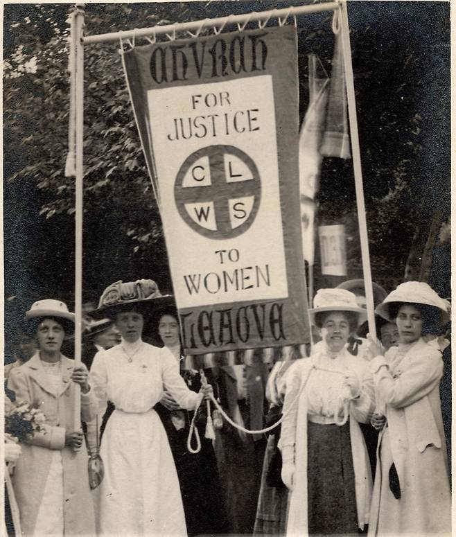 영국 여성 참정권 운동에는 교회 여성이 다수 참여했다. 영국성공회 단체인 여성참정권교회연맹(CLWS) 배너를 들고 있는 여성들. 위키미디어 커먼즈
