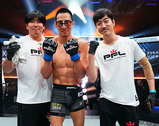 왼쪽부터 미국 플로리다주 올랜도 유니버설 스튜디오에서 2025 PFL 월드 토너먼트 페더급 준결승 진출 기념 촬영을 하는 블랙컴뱃 오피셜짐 최효준 관장, 선수 김태균, 세컨드로 도운 제2대 블랙컴뱃 플라이급 챔피언 김성웅. 사진=MMAX Investment Partners, Inc.