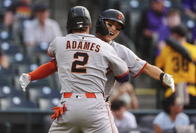 이정후가 12일(한국시간) 콜로라도전 1회 윌리 아다메스의 홈런 때 홈을 밟은 뒤 덕아웃으로 들어오는 아다메스와 기쁨을 나누고 있다.  [AP]