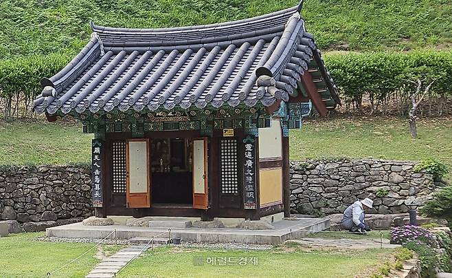 수선사 삼성각 앞 잔디마당의 잡풀을 제거하는 여경 주지 스님 모습.