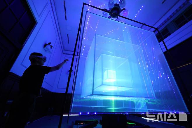 [서울=뉴시스] 황준선 기자 = 12일 서울 용산구 문화역서울 284에서 열린 '우리들의 낙원' 사전 공개 행사에서 관람객이 이상욱 작가의 Hybrid Space  Series 전시를 관람하고 있다. 오는 13일 개막하는 '우리들의 낙원' 전시는 행복과 이상향을 주제로 하여 과거 사람들이 서울역에서 품어왔던 출발, 설렘, 시대, 위안 등 장소성을 되새기며 행복과 이상향을 탐구하는 여정을 VR, 사진, 설치, 영상 등 50여가지 작품으로 선보인다. 2025.06.12. hwang@newsis.com