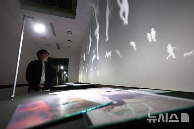 [서울=뉴시스] 황준선 기자 = 12일 서울 용산구 문화역서울 284에서 열린 '우리들의 낙원' 사전 공개 행사에서 관람객들이 이창원 작가의 '평행세계_낙원' 작품을 관람하고 있다. 오는 13일 개막하는 '우리들의 낙원' 전시는 행복과 이상향을 주제로 하여 과거 사람들이 서울역에서 품어왔던 출발, 설렘, 시대, 위안 등 장소성을 되새기며 행복과 이상향을 탐구하는 여정을 VR, 사진, 설치, 영상 등 50여가지 작품으로 선보인다. 2025.06.12. hwang@newsis.com