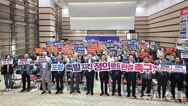 [포항=뉴시스] 송종욱 기자 = 12일 오후 경북 포항시청 대회의실에서 포항 촉발 지진 손해 배상 소송과 관련해 '포항 지진 대시민 토론회 그날'이 열린 가운데 이강덕 시장, 김일만 시의회 의장, 기관 단체장, 공동소송 변호사, 시민이 상고심의 정의로운 판결을 촉구하며 퍼포먼스를 벌이고 있다. 2025.06.12. sjw@newsis.com