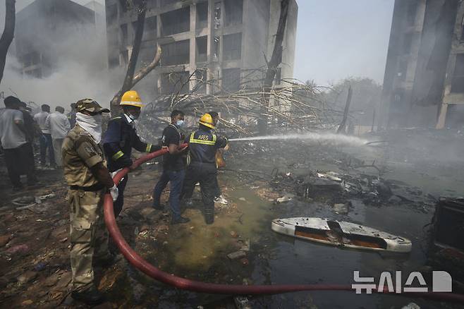 [아마다바드(인도)=AP/뉴시스]인도 소방대원들이 12일 구자라트주 아마다바드의 에어 인디아 AI-171편 보잉 여객기 추락 현장에서 화재를 진압하고 있다. 최소 110명이 사망한 것으로 전해진 이날 사고 직후 미 보잉사 주가는 개장 전 거래에서 약 9% 폭락했다. 2025.06.12.