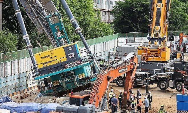 6일 경기&nbsp;용인시 기흥구 서천동 인덕원~동탄 복선전철 공사 현장에서 관계자들이 인근 아파트로 쓰러진 천공기를 살펴보고 있다. 연합뉴스