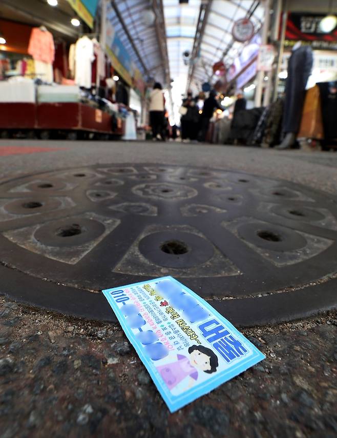 코로나19 당시 발생한 소상공인의 정책자금 대출 탕감을 놓고 논란이 많다. 서울 시내 한 재래시장 바닥에 대출 광고지가 뿌려져 있다. [사진 | 뉴시스]