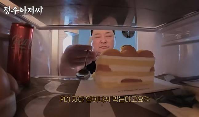자다 일어나 냉장고 속 케이크를 먹는 윤정수. [사진=유튜브 캡처]