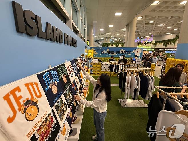 지난 12일 제주국제공항에 열린 '제주국제공항 여객청사 및 상업시설 소개 행사'에서 제주 감귤, 해녀 등을 활용한 의류를 판매하는 '아일랜드 팩토리' 팝업 매장을 선보이고 있다. 2025.6.13/뉴스1