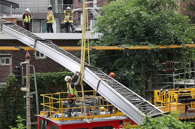 13일 서울 서대문구 경의중앙선 가좌역∼신촌역 구간 선로 위로 사다리차가 넘어져 관계자들이 복구 작업을 하고 있다. 이 사고로 전기공급 장애가 발생, 열차 운행이 지연되고 있다. /연합뉴스
