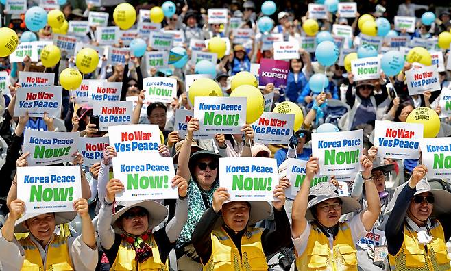 경기도 파주시 문산읍 임진각 ‘평화의 종’ 광장에서 열린 ‘디엠제트(DMZ) 생명평화순례단과 함께하는 한반도 평화대회’ 참석자들이 손팻말을 들어 보이고 있다.