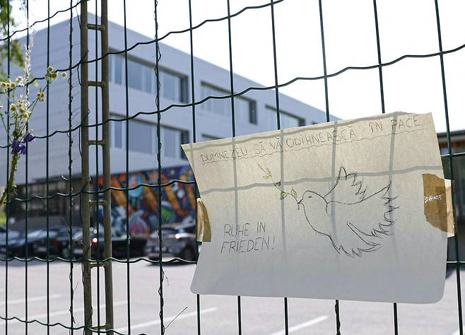 10명의 사망자를 낸 학교 난동 사건 이후인 지난 12일(현지시간) 오스트리아 남동부 그라츠의 한 고등학교 앞에 루마니아어(위)와 독일어로 ‘신의 평화가 함께하길’이라고 적힌 애도의 표현이 걸려 있다. AFP=연합뉴스