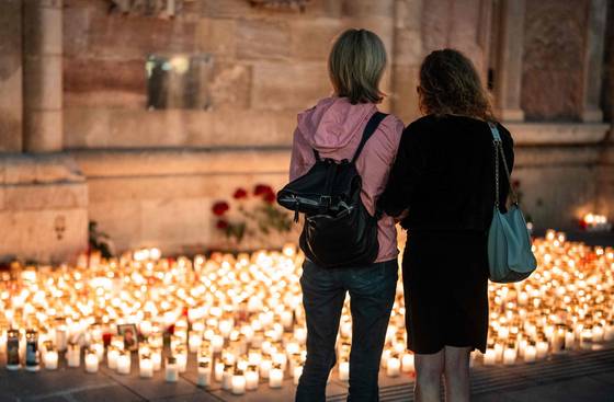 오스트리아 남동부 그라츠의 한 고등학교에서 총격으로 10명이 사망한 지 하루 뒤인 지난 11일(현지시간) 빈 성슈테판 대성당(슈테판스돔) 앞에 마련된 임시 추모비에서 여성들이 희생자들을 추모하고 있다. AFP=연합뉴스