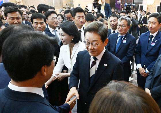 이재명 대통령과 부인 김혜경 여사가 지난 4일 서울 여의도 국회 로텐더홀에서 열린 제21대 대통령 취임선서를 마친 뒤 더불어민주당 의원들과 악수를 나누고 있다. 국회사진기자단