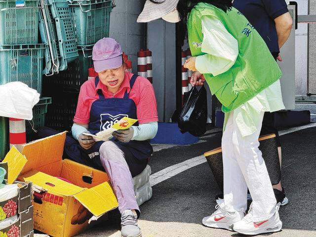 서울중앙시장 상인이 전도지를 받고 읽어보는 모습.