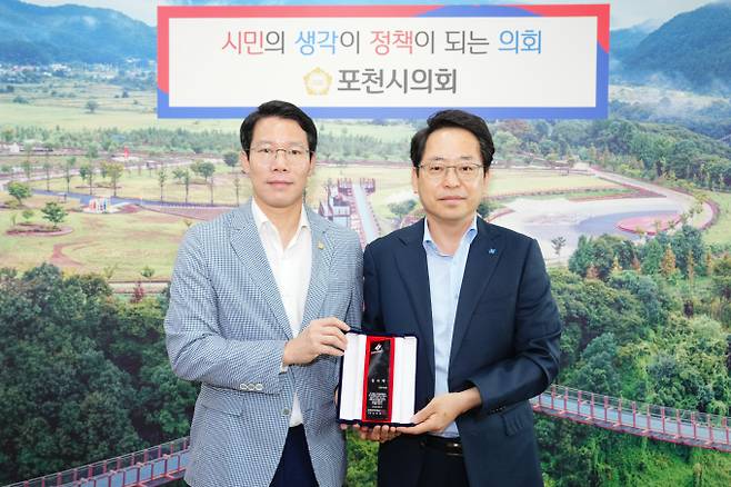 임종훈 포천시의회 의장(왼쪽)이 13일 남화영 한국전기안전공사 사장으로부터 감사패를 수여 받고 있다. /사진제공=포천시의회