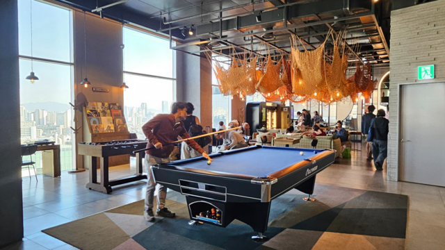 지난달 28일 서울 마포구 L7 홍대 바이 롯데 로비에서 외국인 투숙객들이 다양한 활동을 즐기는 모습. 로비는 빈티지 가구로 채워졌으며 한쪽에는 당구대와 이광호 작가의 작품이 배치돼 있다.