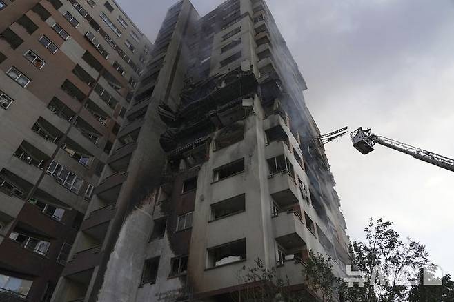 [테헤란=AP/뉴시스] 13일(현지 시간) 이란 테헤란 북부에서 소방관들이 이스라엘 공습으로 폭발이 발생한 주거 단지 아파트 건물에 접근하고 있다. 이스라엘방위군(IDF)은 이날 새벽 이스라엘이 이란의 핵·군 시설에 대한 선제타격을 개시했다고 성명을 통해 밝혔다. 2025.06.13.