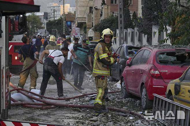 [테헤란=AP/뉴시스] 13일(현지시간) 뉴욕타임스는 미국은 중동 전쟁에 휘말리는 것을 피하려 하면서도, 이란의 보복에 대응해 이스라엘을 방어할지 고민에 빠져 있다며 확전을 막기 위해 트럼프 행정부는 외교적으로 이란 핵합의를 복원해야 한다고 보도했다. 사진은 13일(현지 시간) 이란 테헤란 북부의 한 주거 단지에서 이스라엘의 공습으로 폭발이 발생한 후 소방관들과 주민들이 잔해를 치우고 있는 모습. 2025.06.13.