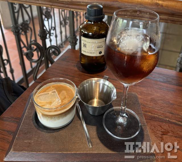 ▲ 베트남 ‘카페 탄(tan.)’의 여름 시그니처 메뉴. 와인 글라스에 담은 싱글오리진 콜드브루와 연유 아이스 라테가 한 트레이에서 진하고 달콤한 맛을 함께 선보이고 있다. ⓒ프레시안(문상윤)