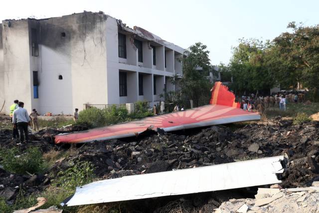 12일(현지 시간) 인도 아흐메다바드에서 추락한 에어 인디아 여객기의 꼬리 부분을 구조대원들이 살펴보고 있다. 런던행 보잉 787-8 드림라이너 여객기는 이륙 직후 추락해 200명 이상이 사망했다. 연합뉴스