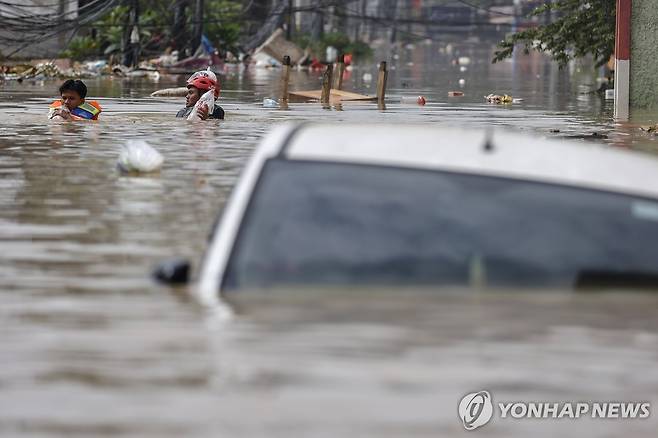 인도네시아 홍수 지난 3월 4일 인도네시아 수도 자카르타 동부 위성도시 브카시에 발생한 홍수로 차와 사람들이 물에 잠긴 모습.
[EPA 연합뉴스 자료사진. 재판매 및 DB 금지]