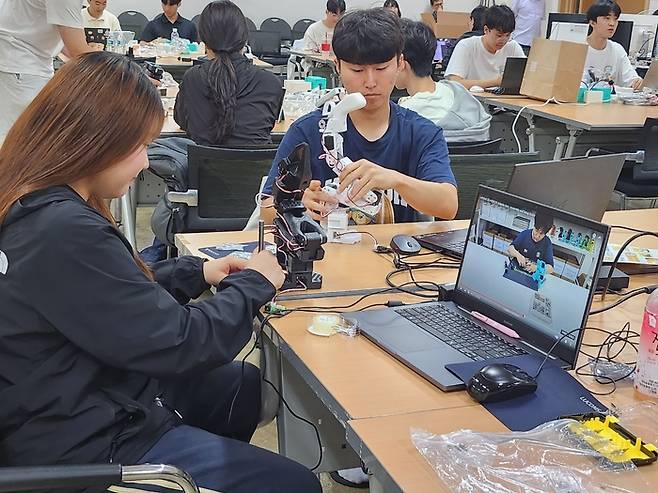 참가자들이 주어진 로봇팔(SO-101)을 정교하게 조립하며 구현 아이디어를 현실화하고 있다.