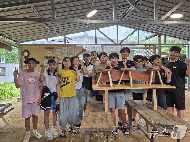 자연생태목공 체험에 나선 학생들이 서로 협동하여 나무 의자를 만든 뒤 기념사진을 찍고 있다.(전남도교육청 제공, 재판매 및 DB 금지)