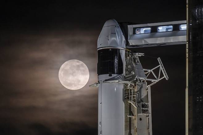 몸을 낮춘 보름달이 스페이스엑스의 팰컨9 로켓과 우주선을 훔쳐보듯 지나가고 있다. 스페이스엑스 제공