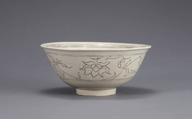 백자 상감 연꽃 넝쿨무늬 대접(국보). 15세기 작품으로, 연한 상아색은 백자를 향해 가고 있는 과정에 있다. 표면에 가늘고 탄력있는 선으로 연꽃과 넝쿨무늬를 새겼는데 이는 명나라 처오하백자 무늬와 비슷하다. 선을 파내고 어두운 흙을 넣는 상감 기법으로 장식했는데, 고려 도자기의 기법을 이어받았다. 오래된 요소와 새로운 요소, 전통과 외래의 것이 조화를 이룬 조선 초기의 발전상을 상징적으로 보여주는 유물이다.