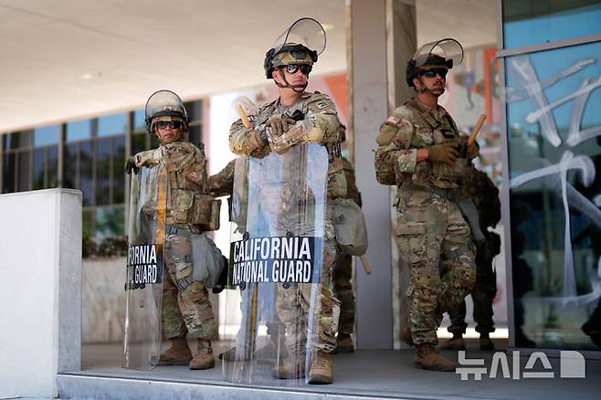 [로스앤젤레스=AP/뉴시스] 로스앤젤레스(LA) 불법 이민자 단속 반대 시위 8일차이자 도널드 트럼프 대통령의 권위주의를 규탄하는 '노 킹스' 시위를 하루 앞둔 13일(현지 시간) 미국 해병대 병력 현장 투입이 시작됐다. 사진은 지난 9일 LA 연방 교정센터 앞에서 주방위군이 경계 근무를 서는 모습. 2025.06.10.