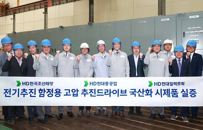 김성준 HD한국조선해양 대표(왼쪽에서 여덟 번째), 주원호 HD현대중공업 특수선 사업대표(왼쪽에서 다섯 번째), 김영기 HD현대일렉트릭 대표(왼쪽에서 일곱 번째), 설승기 HD현대 기술자문(왼쪽에서 여섯 번째) 등 관계자들이&nbsp;‘고압 추진 드라이브’&nbsp;제품을 개발하고 기술 시연회를 갖고 기념촬영을 하고 있다. HD현대 제공&nbsp;
