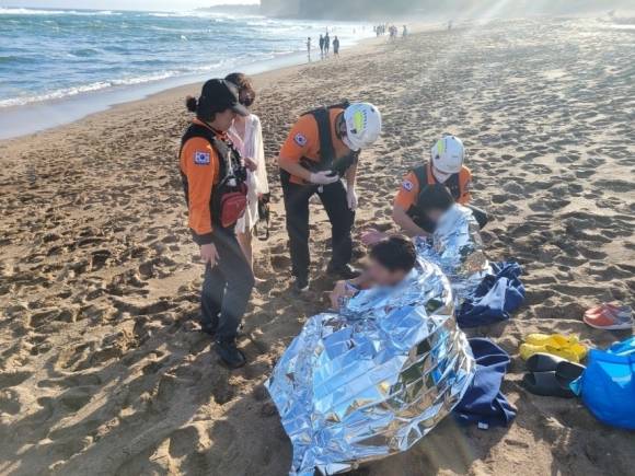 14일 오후 제주 중문해수욕장에서 구조된 10대 2명이 소방대원들의 처치를 받고 있다. 제주소방안전본부 제공