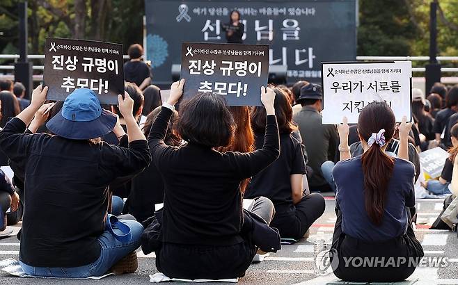 "진상규명이 추모다" (제주=연합뉴스) 변지철 기자 = 30일 오후 제주도교육청 앞마당에서 열린 제주 모 중학교 교사 추모 문화제에서 참가자들이 '진상규명이 추모다'란 피켓을 들어 올리며 구호를 외치고 있다. 2025.5.30 bjc@yna.co.kr