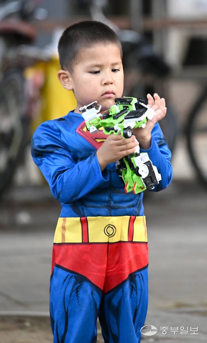 2025 송도굿마켓 행사에서 장난감을 획득한 어린이가 진지하게 물건을 살펴보고 있다.정선식기자