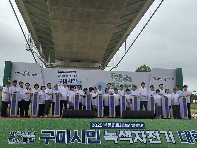 2025 낙동미로(美路) 릴레이 구미시민 녹색자전거 대행진 개회식 참가 내빈들과 학생들이 '생활 속 탄소중립 자전거가 답이다' 퍼포먼스를 하고 있다. <박용기 기자>