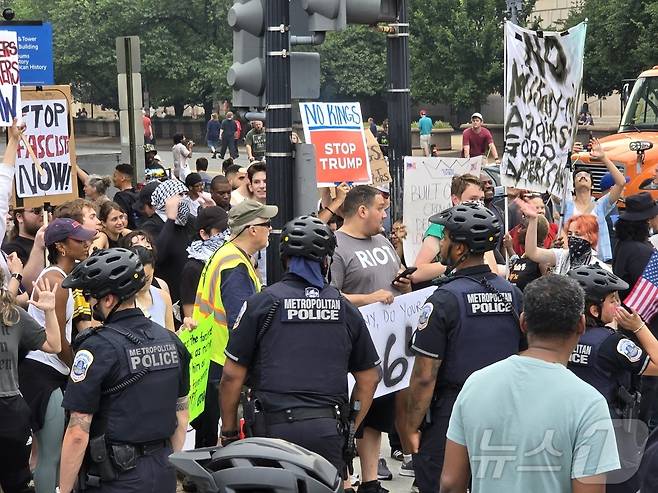 14일(현지시간) 미국 수도 워싱턴DC에서 미 육군 창설 250주년 열병식이 열린 가운데, 도널드 트럼프 행정부 정책에 반대하는 참가자들이 경찰과 대치하고 있다. ⓒ News1 류정민 특파원