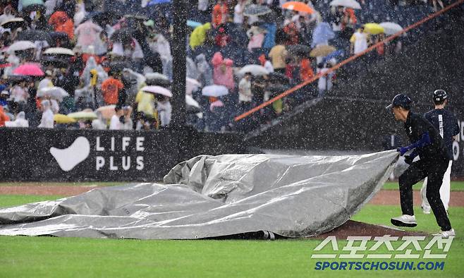 15일 대전 한화생명볼파크에서 열린 한화와 LG의 경기. 5회말 한화가 5대 4로 앞선 가운데 우천 중단되고 있다. 마운드를 방수포로 덮고 있는 경기 진행 요원들. 대전=송정헌 기자songs@sportschosun.com/2025.06.15/
