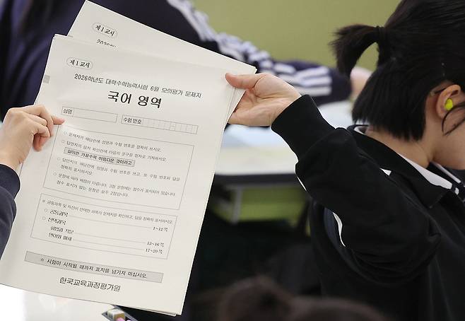 2026학년도 대학수학능력시험 6월 모의평가가 치러진 지난 4일 오전 대구 수성구 대구여자고등학교에서 고3 학생들이 1교시 국어 영역 문제지를 뒤로 전달하고 있다. /뉴스1
